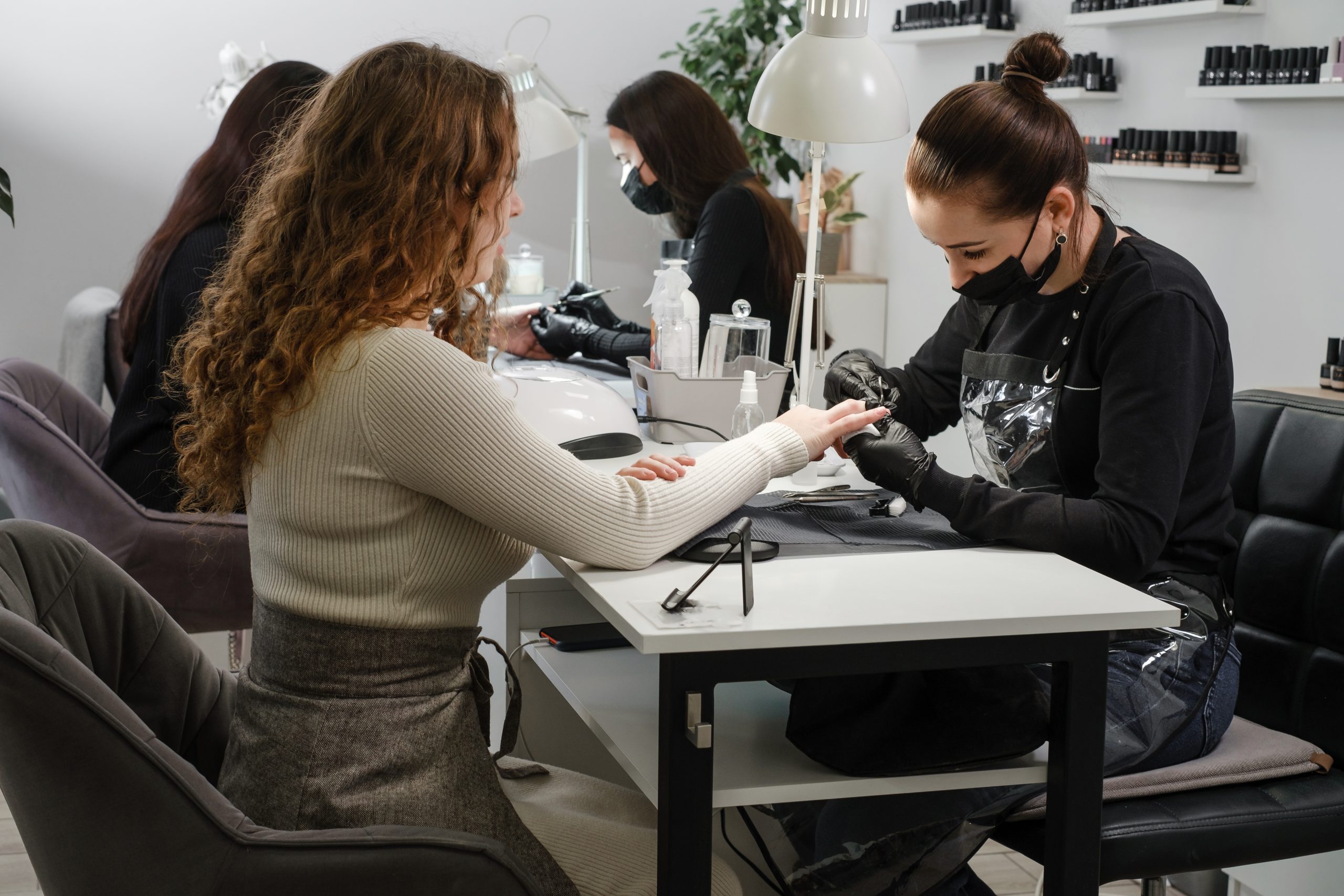 Nail salon with clients receiving manicures and pedicures, showcasing nail art. Nail salon with clients receiving manicures and pedicures, showcasing nail art.